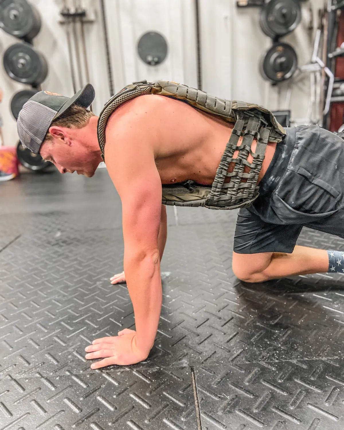A member grinding through a workout in a weighted vest